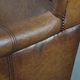 Fauteuil à oreilles de style anglais couleur cognac en cuir de vache.