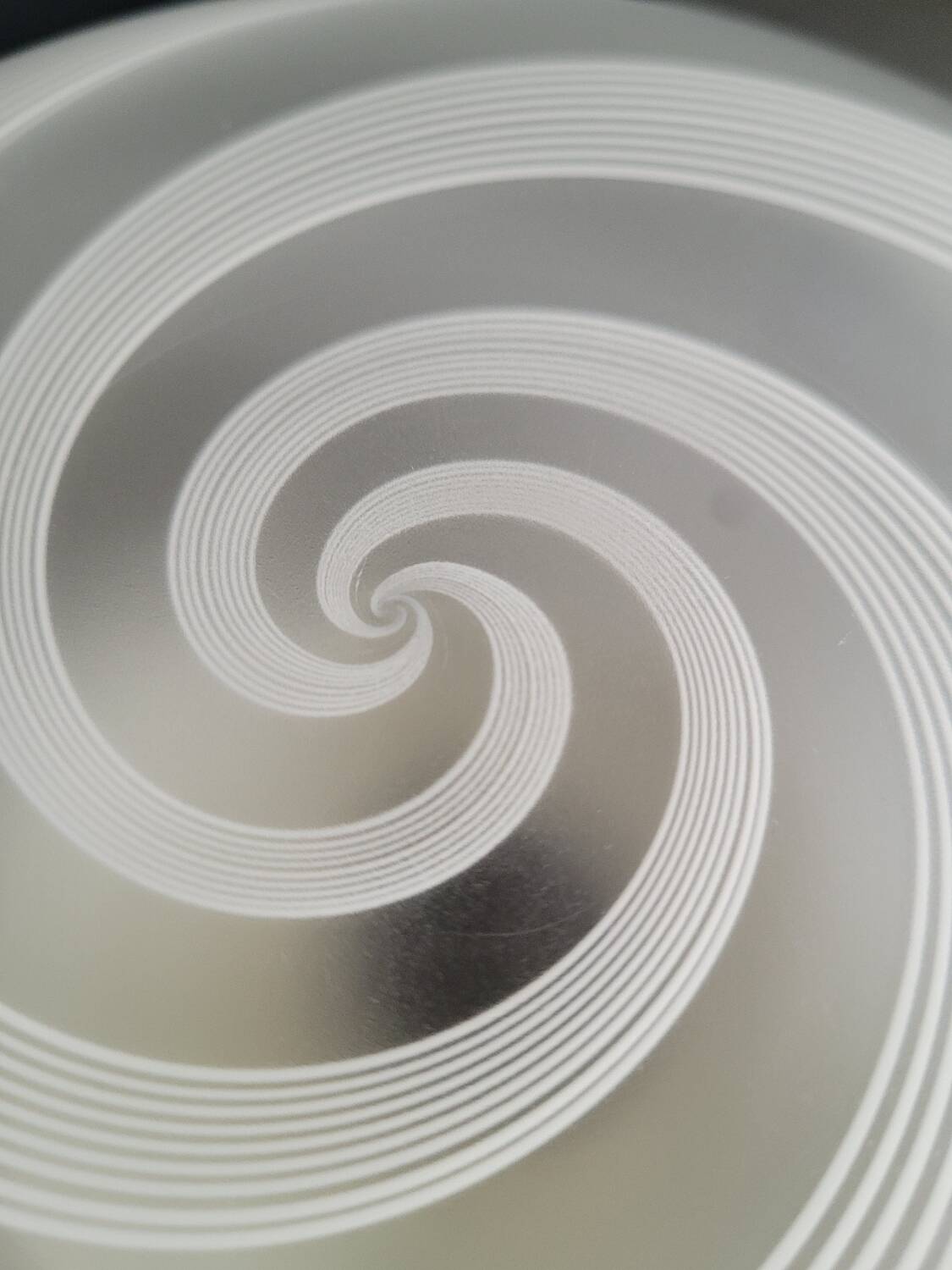 Frosted glass globe ceiling light with spiral patterns.