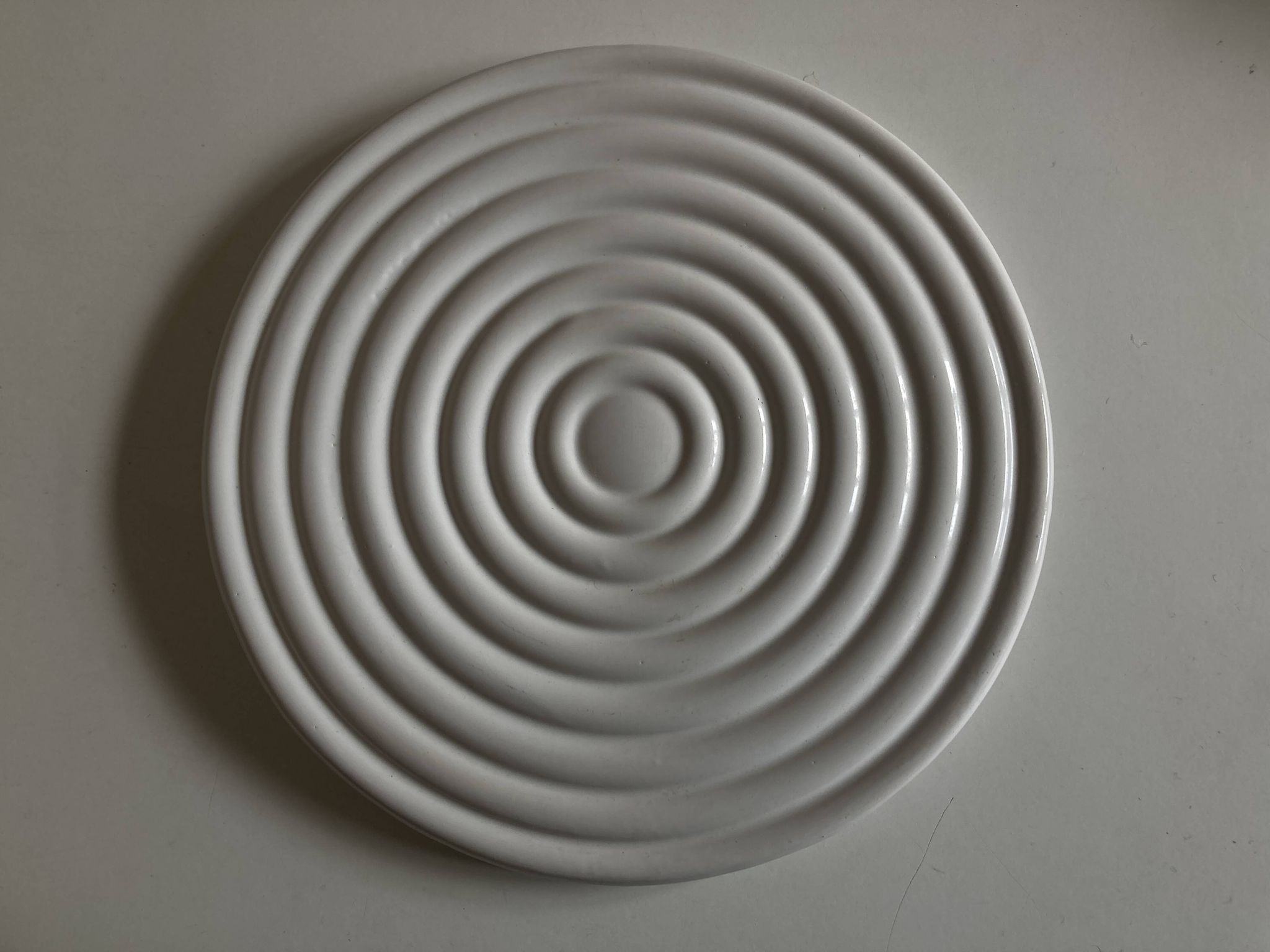 White glazed earthenware potter's trivet