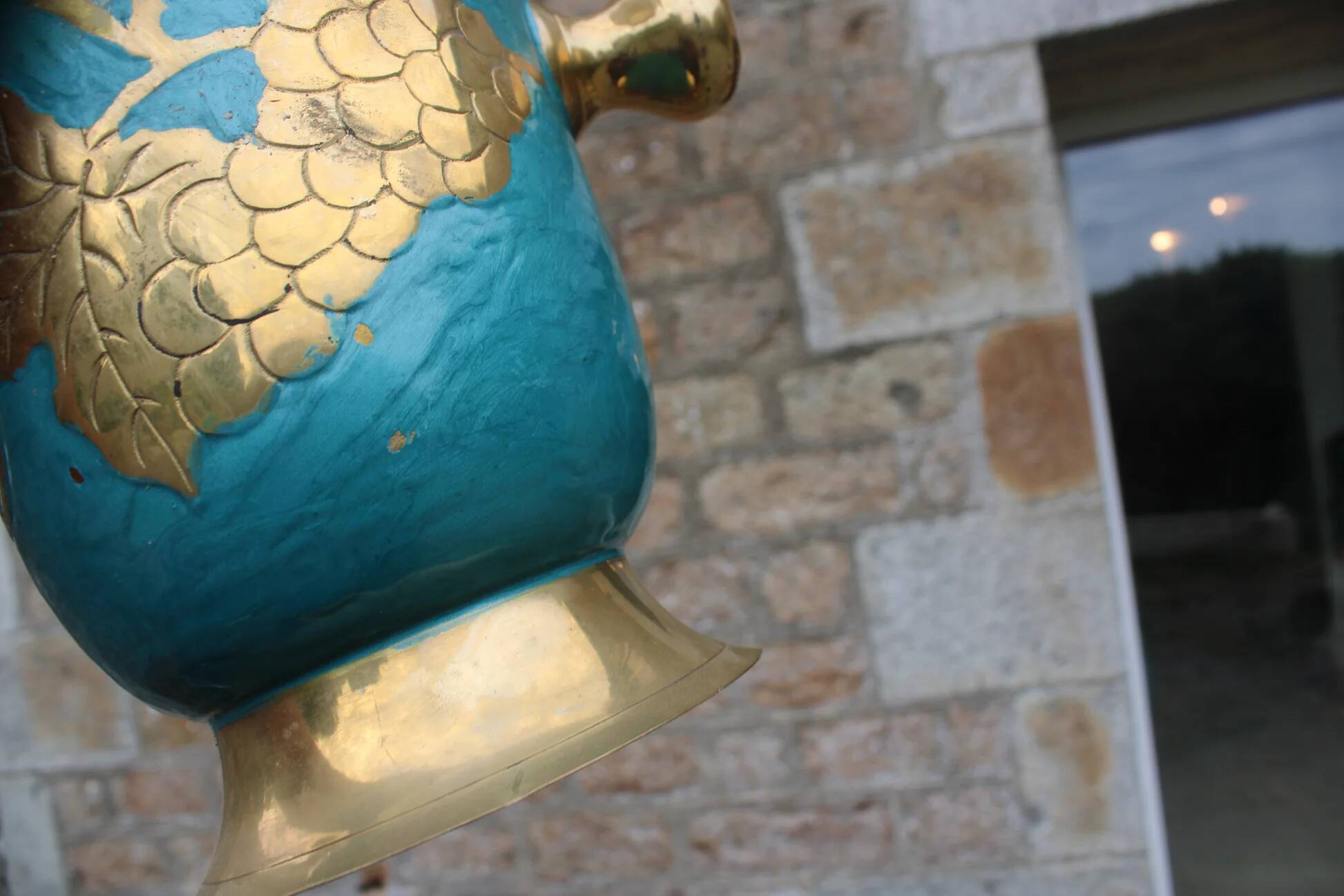 Vintage turquoise brass champagne bucket with grape decoration.