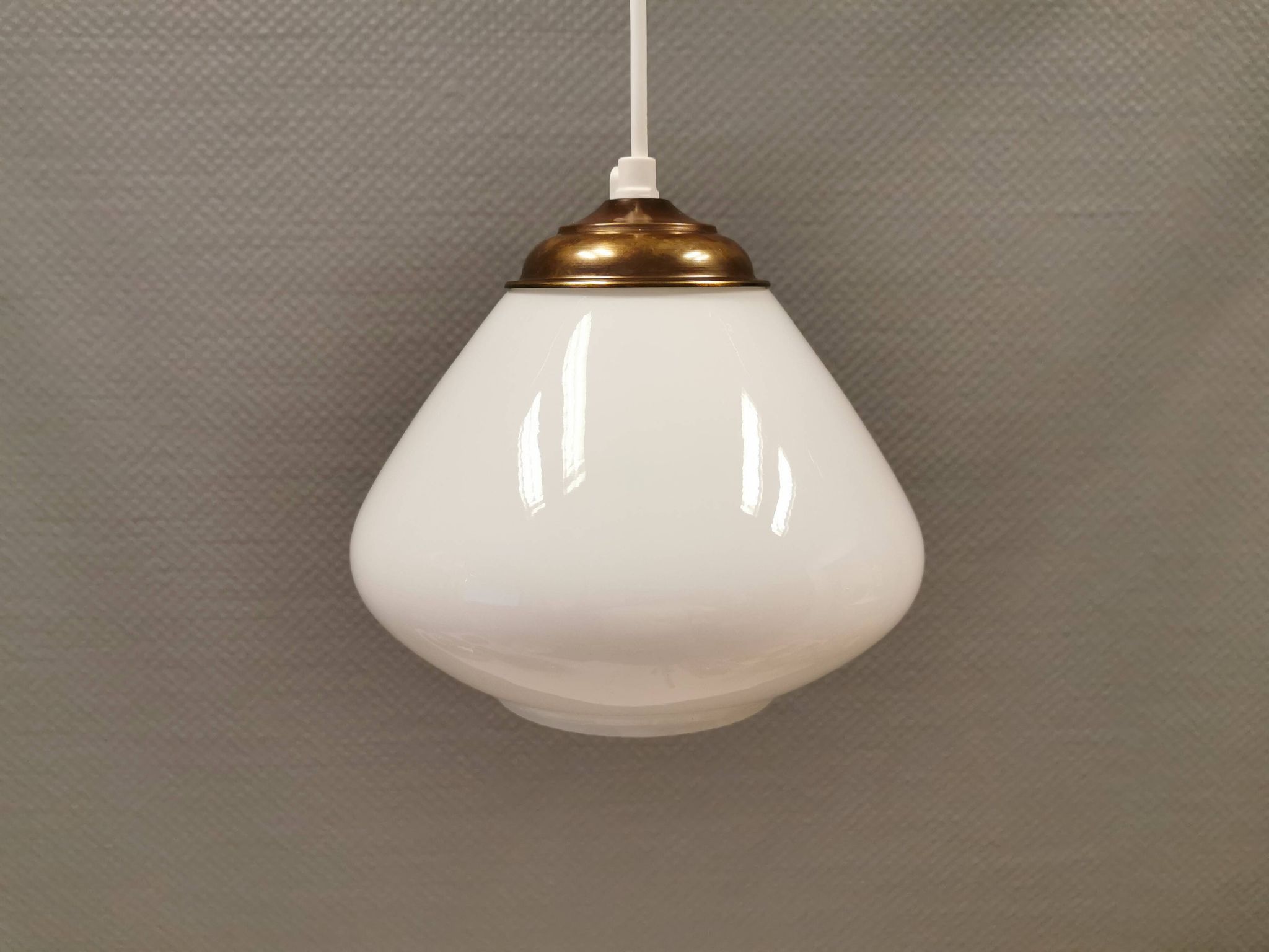 Beautiful ball-shaped hanging lamp in white opal glass with brass top.