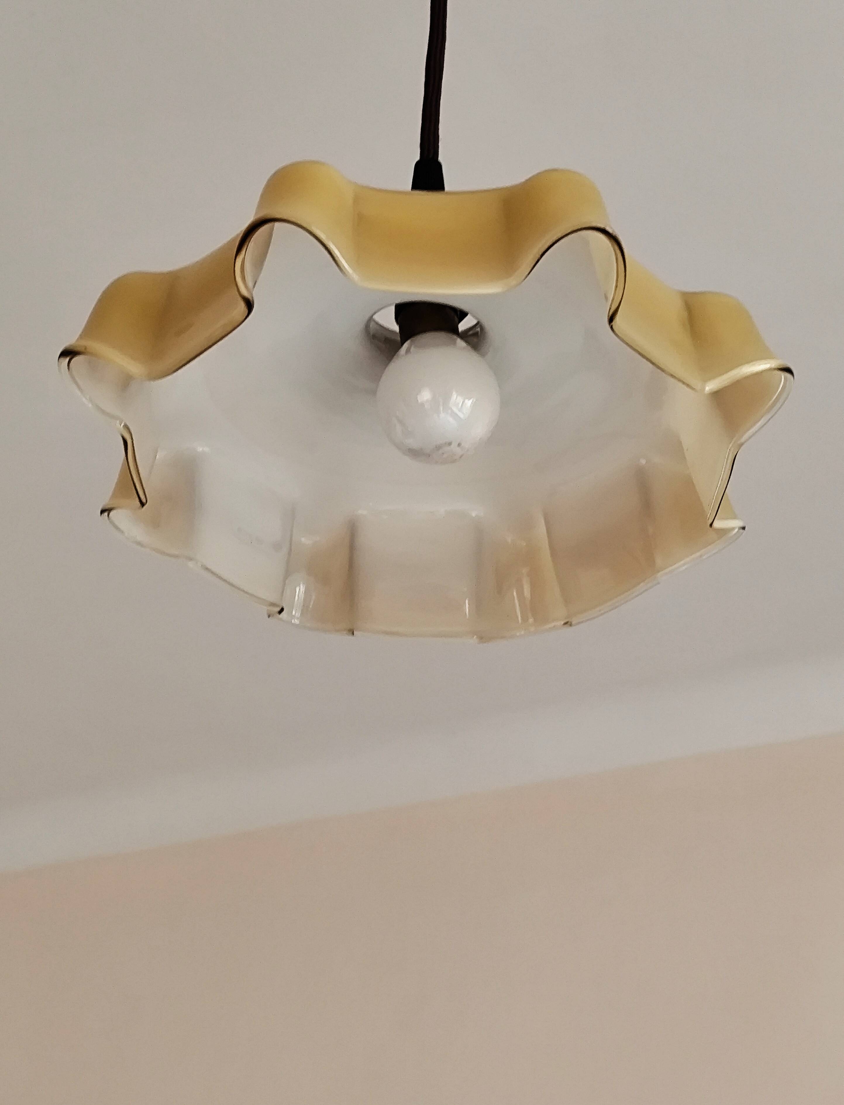 Electrified suspension with a frosted opaque glass disc shade.