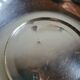 Shallow round metal plate with pearl row decoration.