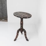 Vintage side table from the early 19th century, dark wood with mother-of-pearl inlays, oval shape with three legs, ethnic style.