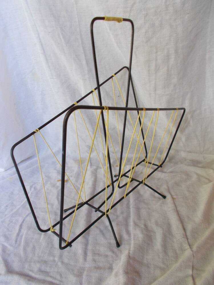 Black metal magazine rack with yellow scoubidou wire.
