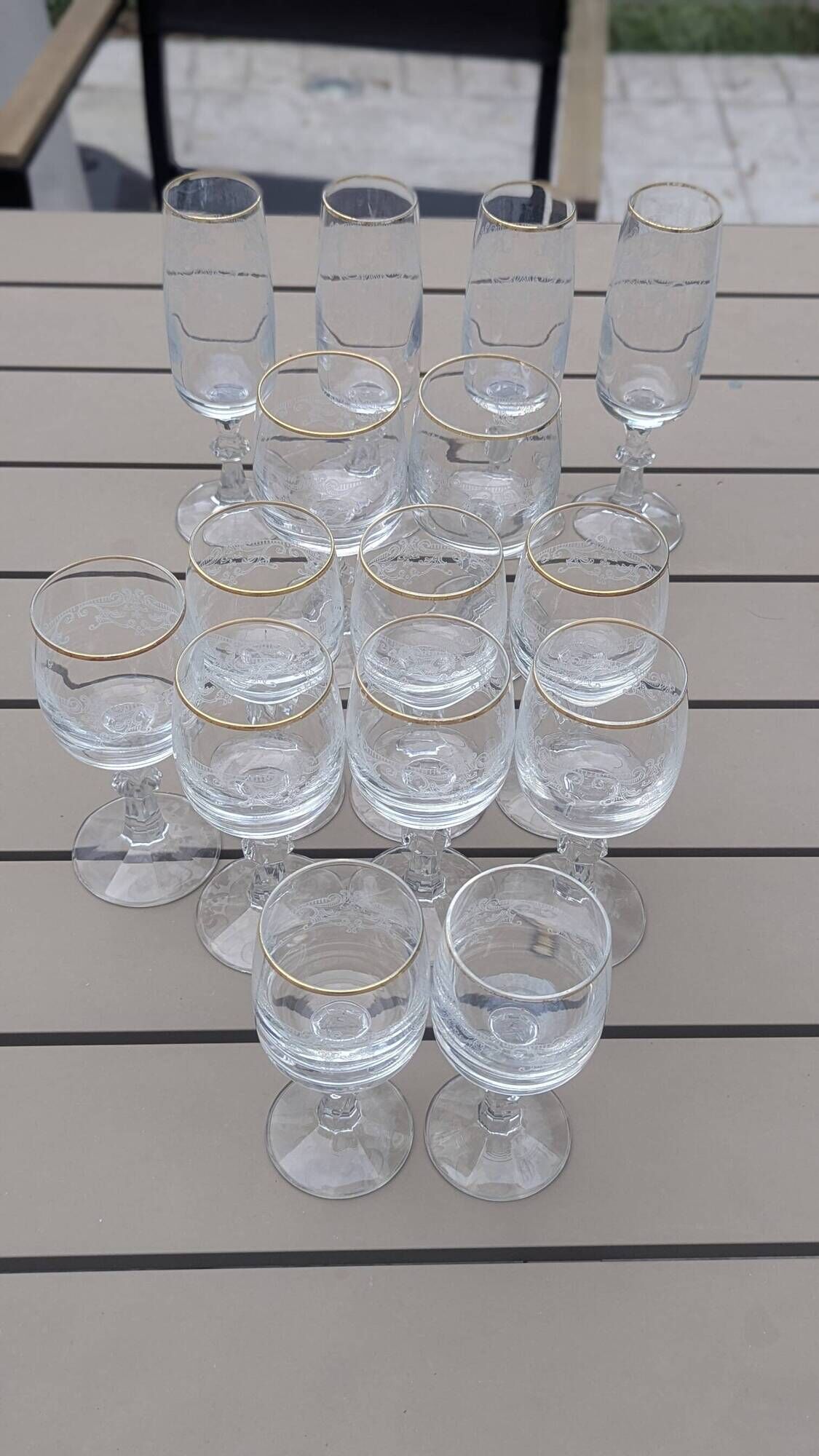 Set of 15 engraved crystal glasses with a gold rim.