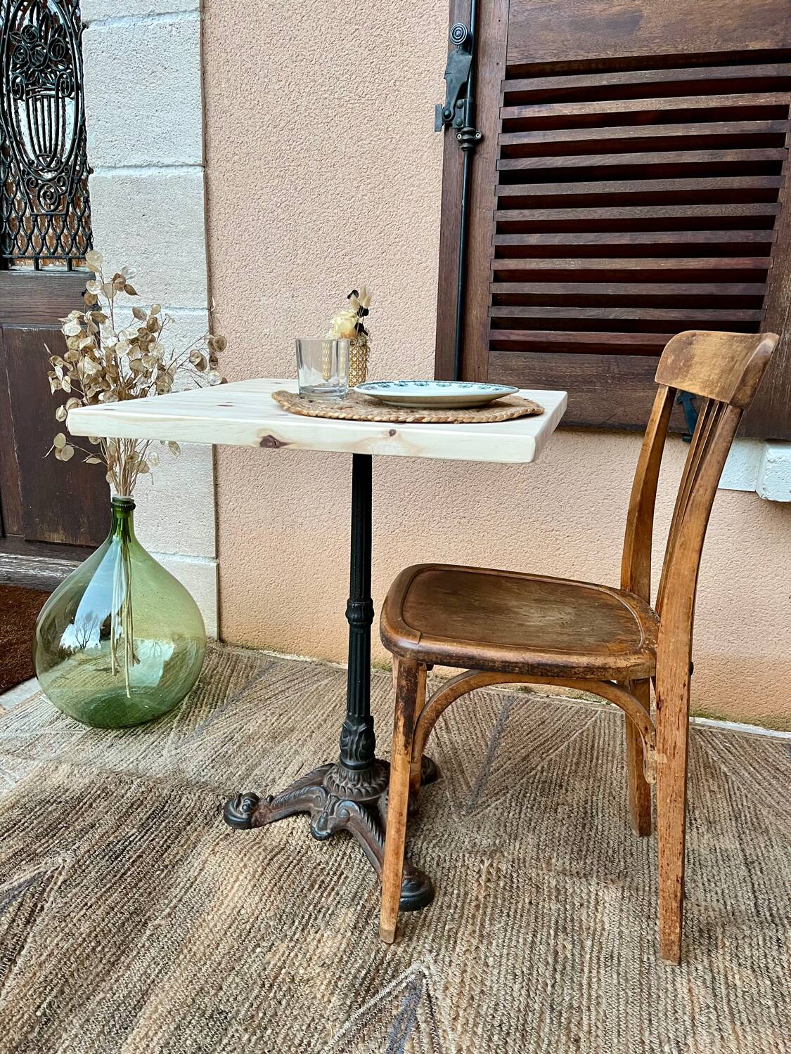 Bistro table with a raw wood top and a central cast iron base.