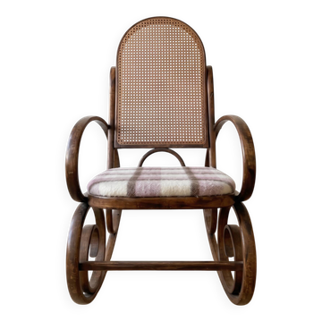 Antique rocking chair in curved wood and caning.