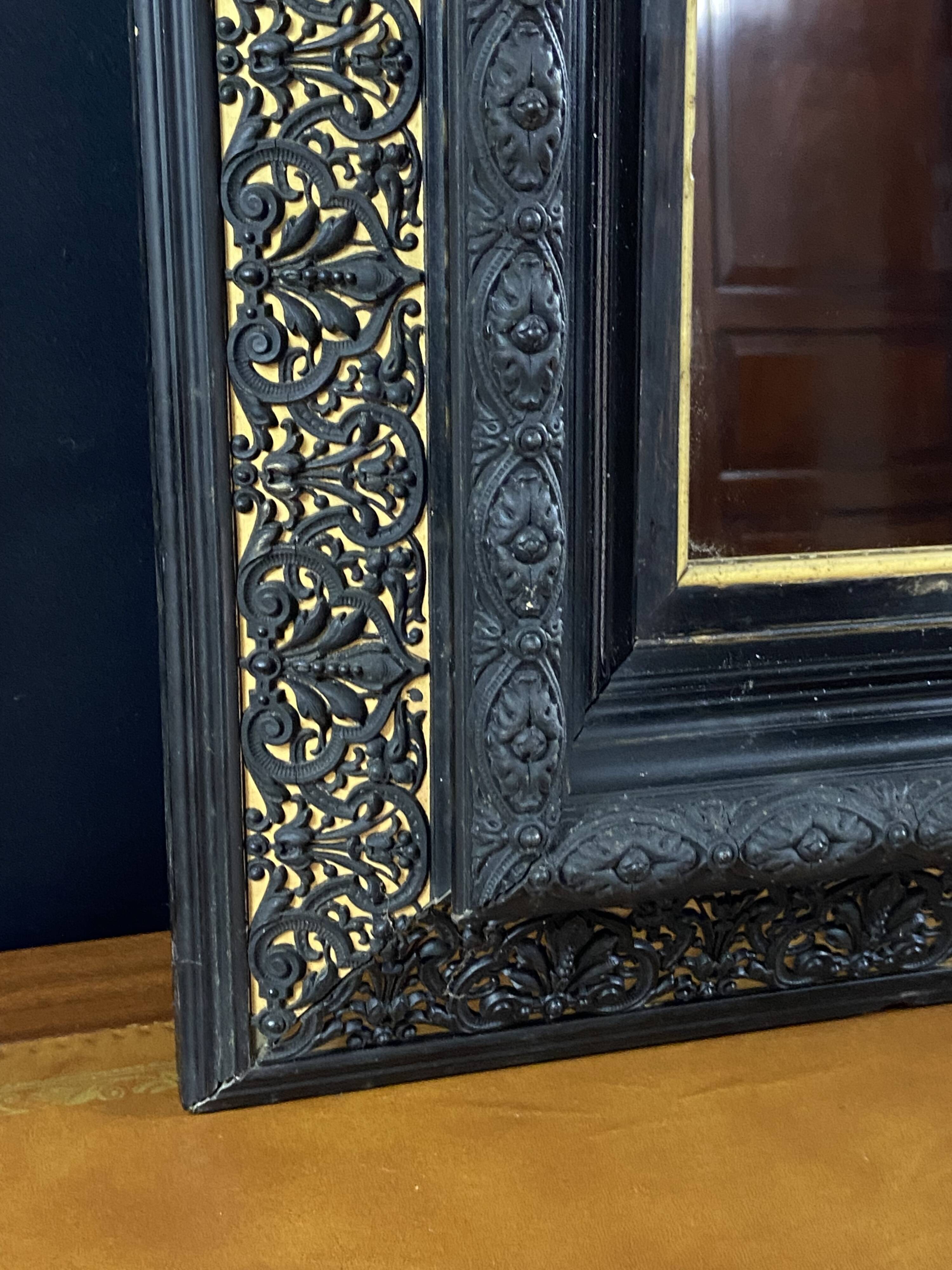 19th-century mirror Napoleon III in blackened wood on a gold background.