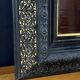 19th-century mirror Napoleon III in blackened wood on a gold background.