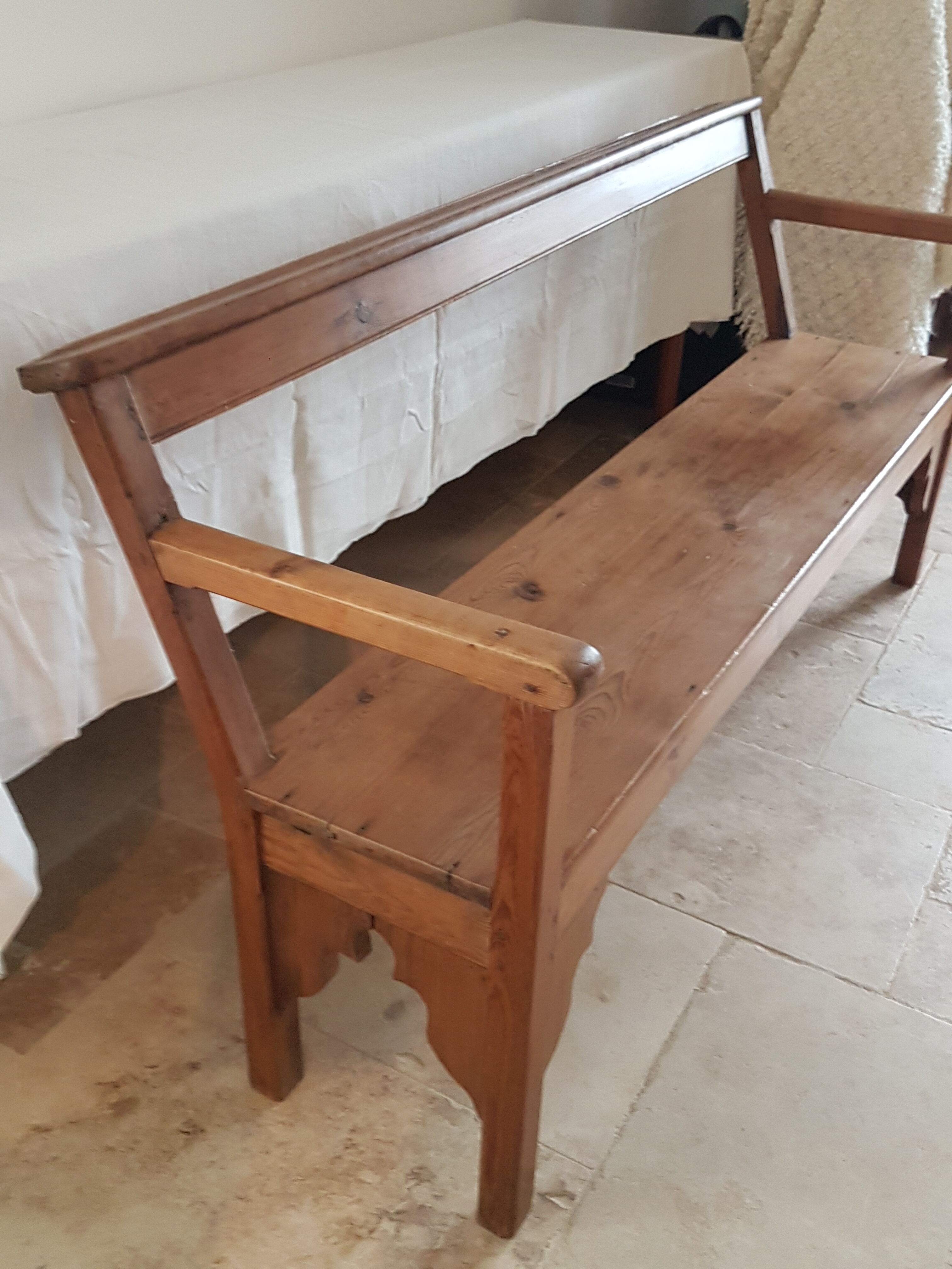 Church bench in fir tree with armrests