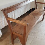 Church bench in fir tree with armrests