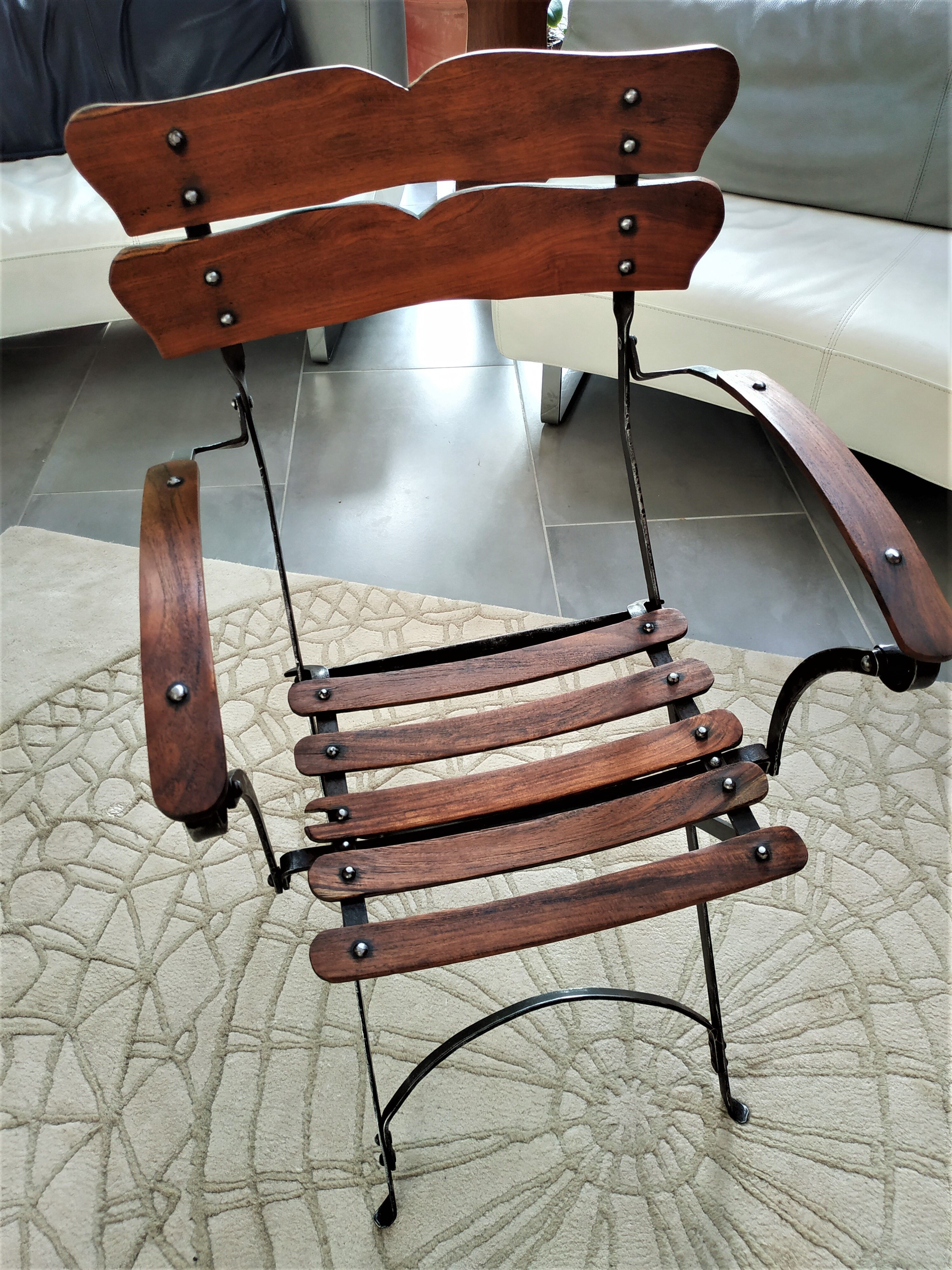 Folding garden chair with teak slats on a wrought iron structure