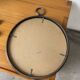 Brutalist round mirror with wrought iron and studs.