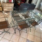 Wrought iron table with duckbill profile glass top and 6 armchairs