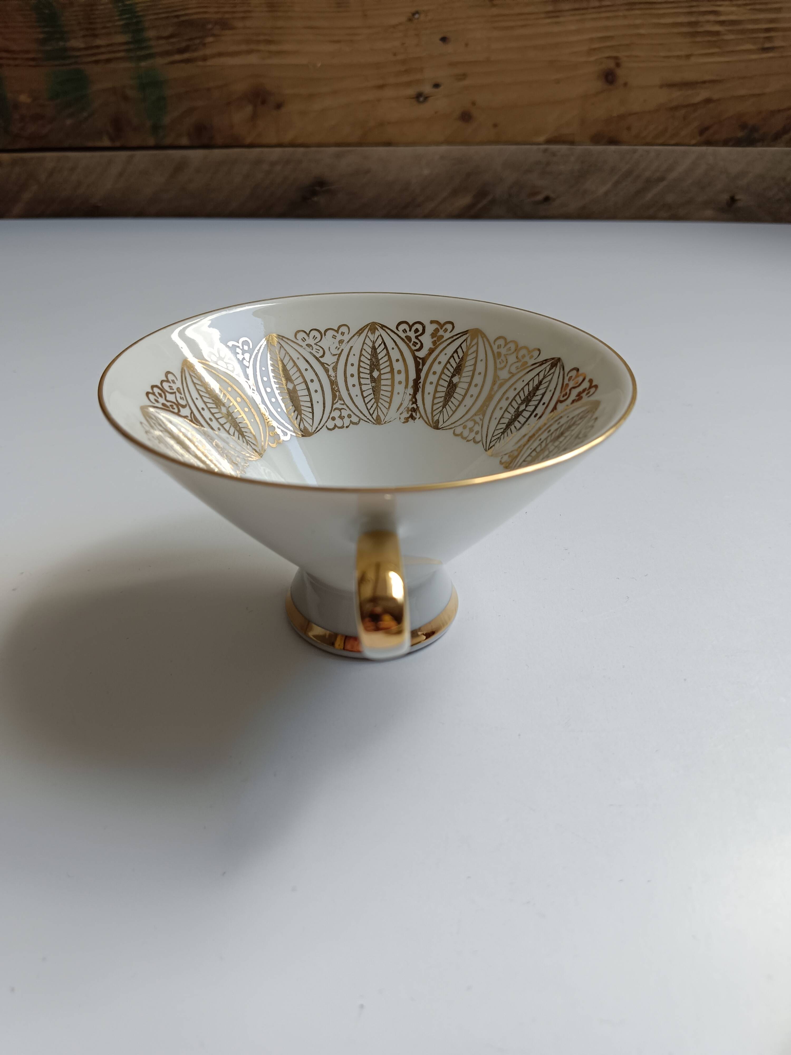 Solitaire tea cup, saucer, and dessert plate in white and gold.