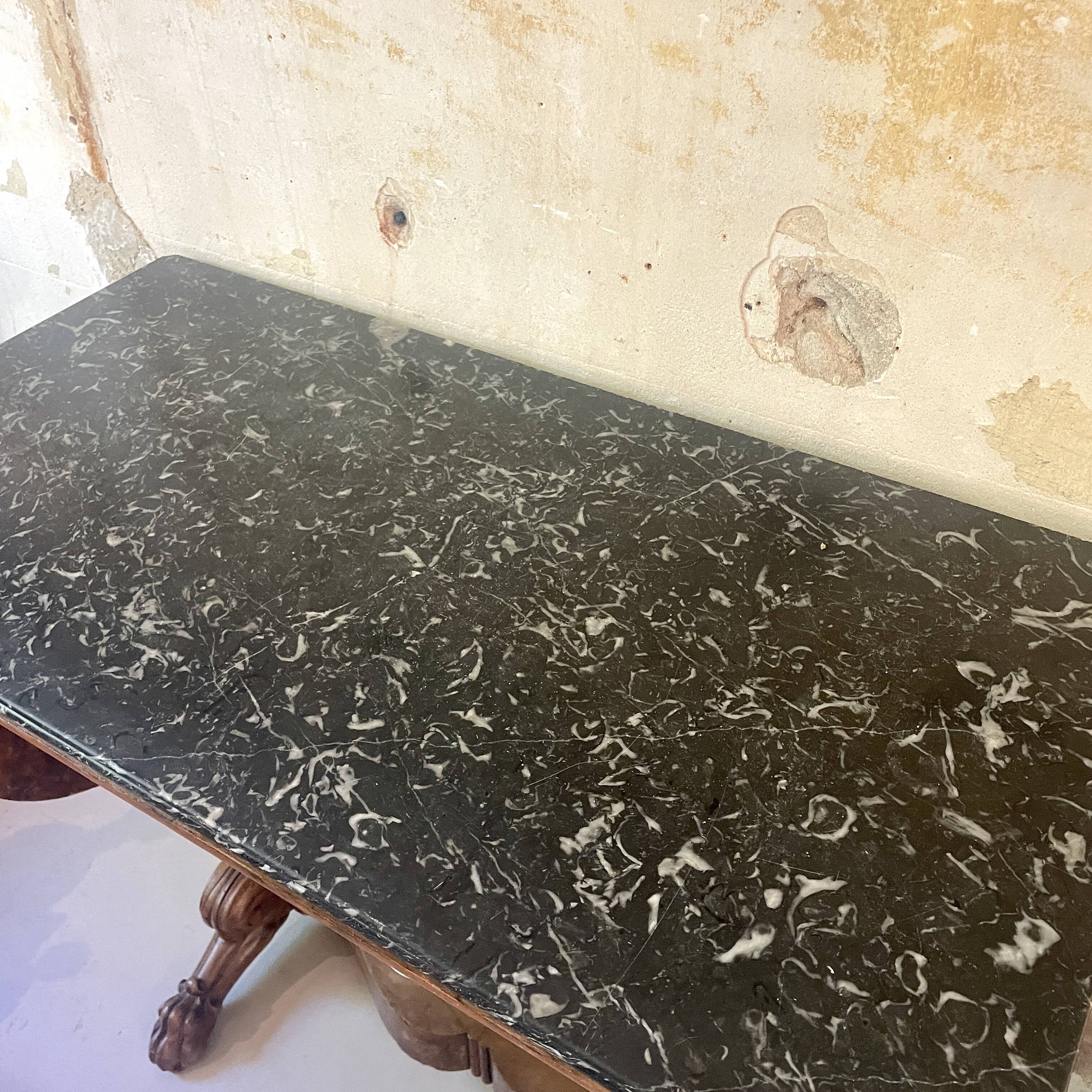 Console inlaid with black marble and lion's paw legs.