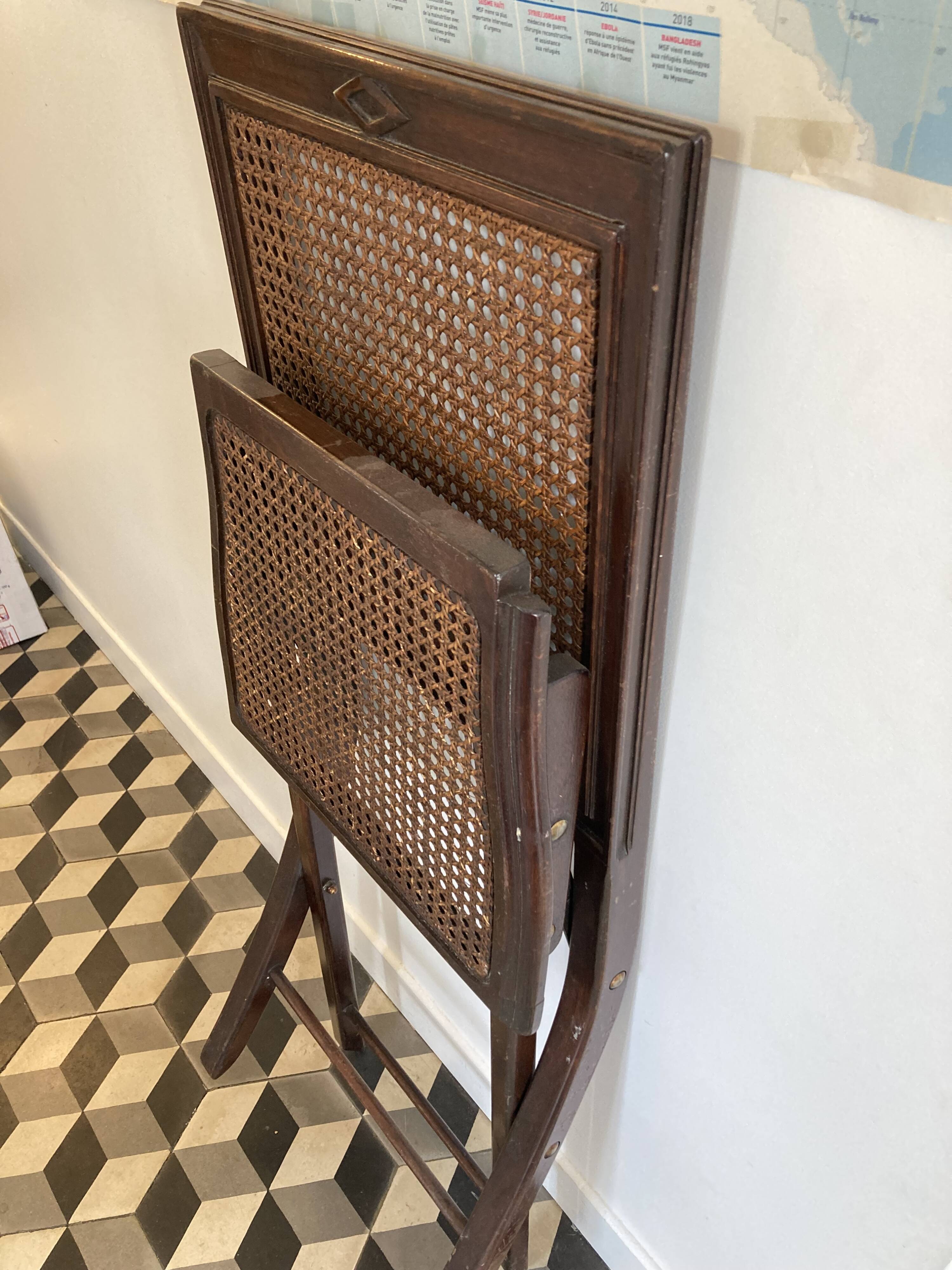 Vintage folding chair with cane seat in dark mahogany wood