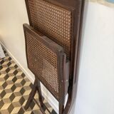 Vintage folding chair with cane seat in dark mahogany wood