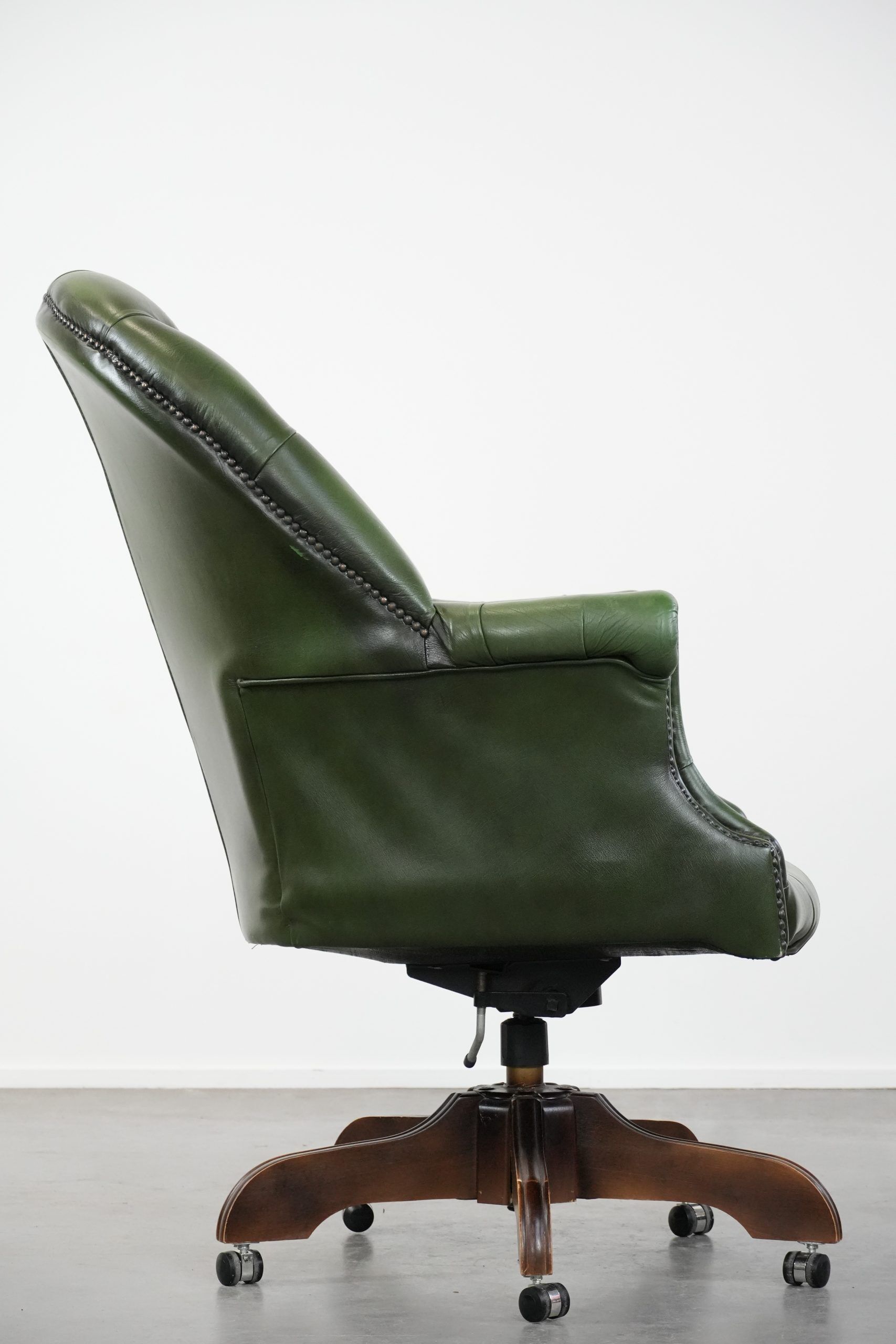 Large green cowhide Chesterfield office chair in English style on wheels