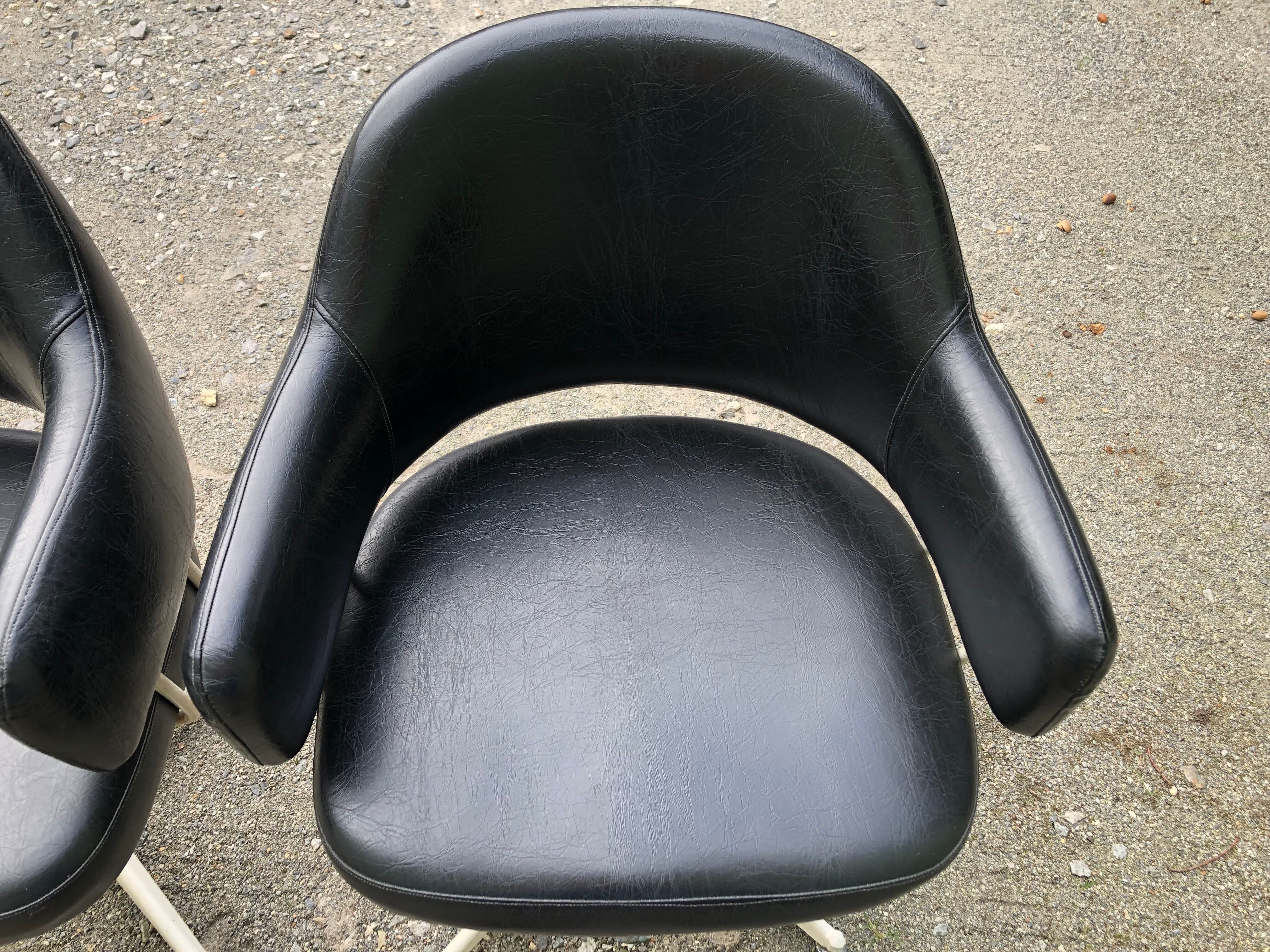 Pair of vintage armchairs in black skai with metal legs.