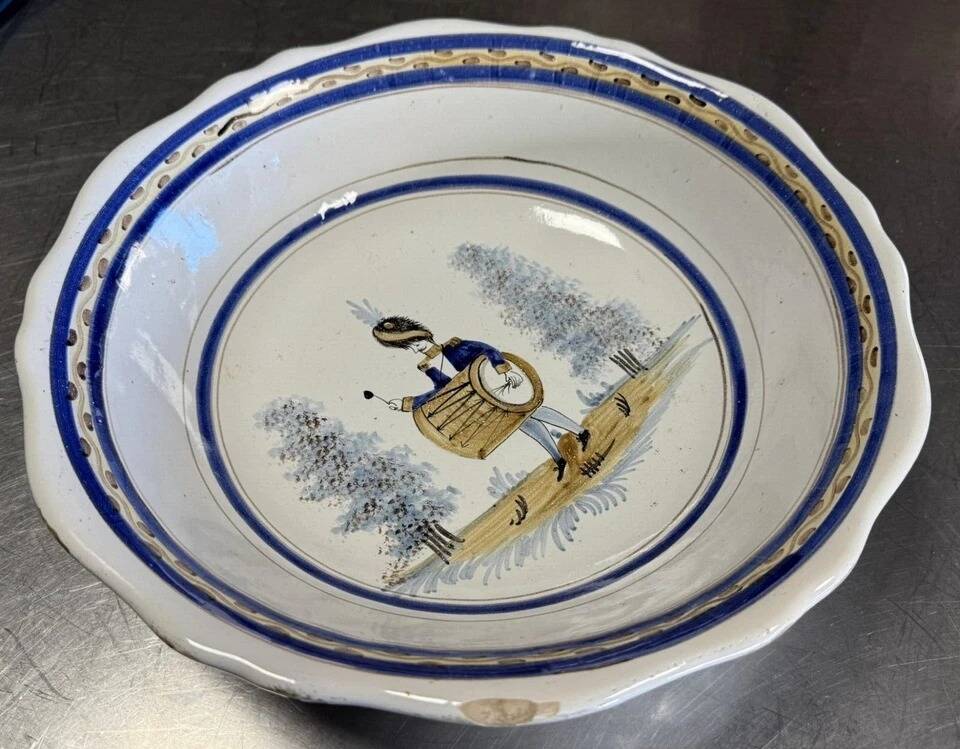 Large earthenware centerpiece dish with painted decoration of a drummer