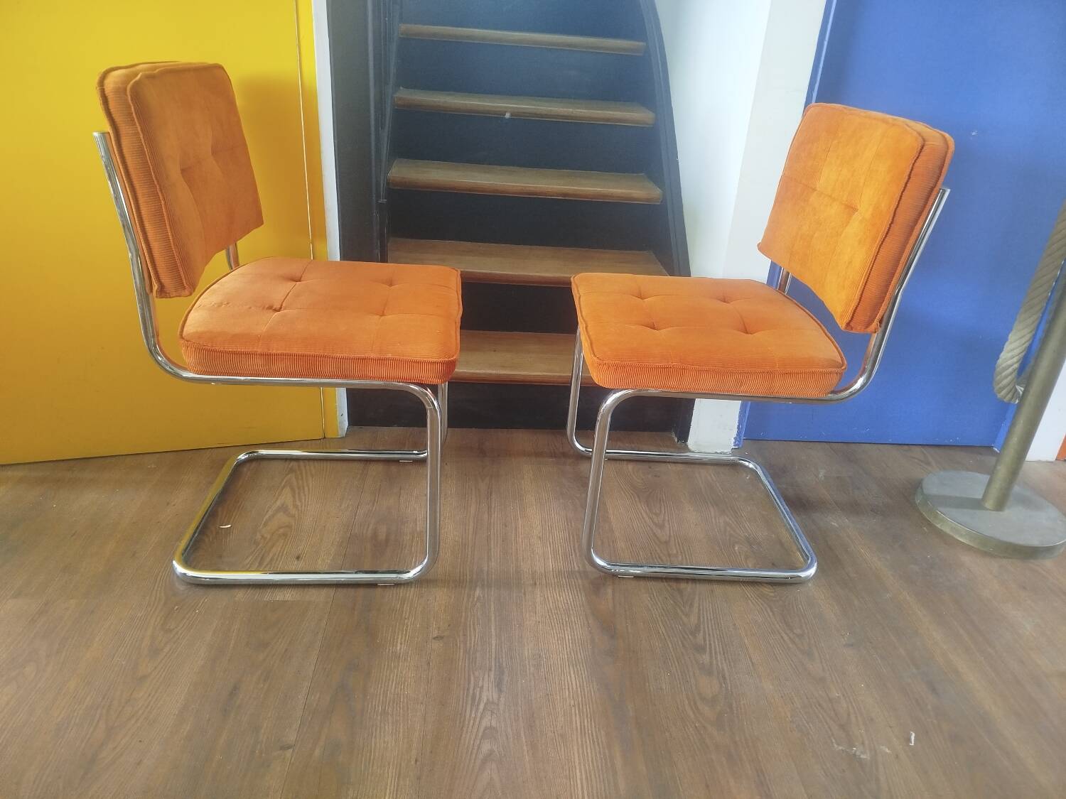 Pair of vintage cantilever chairs in chrome and orange corduroy.