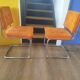 Pair of vintage cantilever chairs in chrome and orange corduroy.