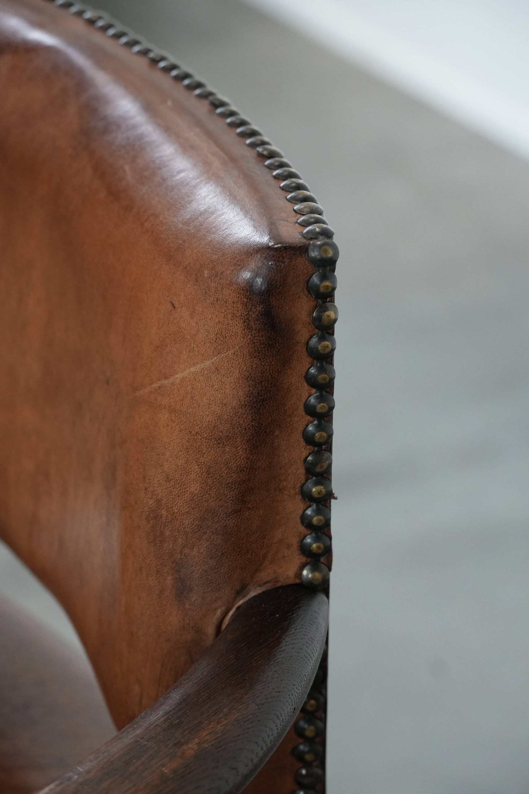Elegant antique sheepskin leather desk chair with a heavy wooden frame