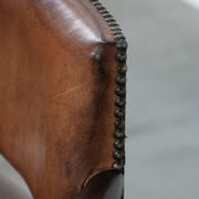 Elegant antique sheepskin leather desk chair with a heavy wooden frame