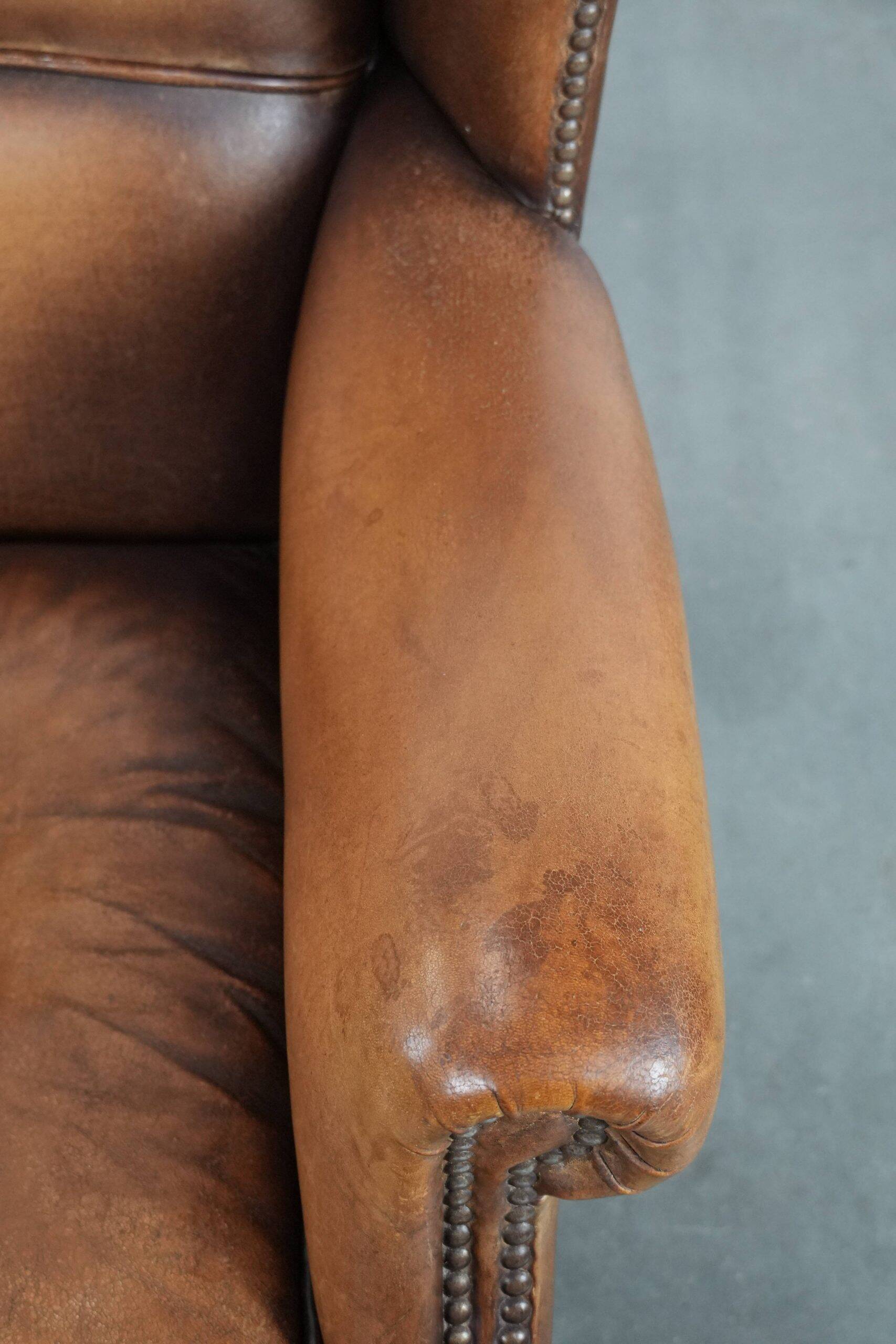 Fauteuil à oreilles en cuir de mouton charmant avec des couleurs chaudes.