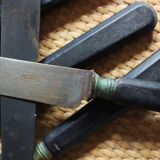 A set of 8 knives with black wooden handles