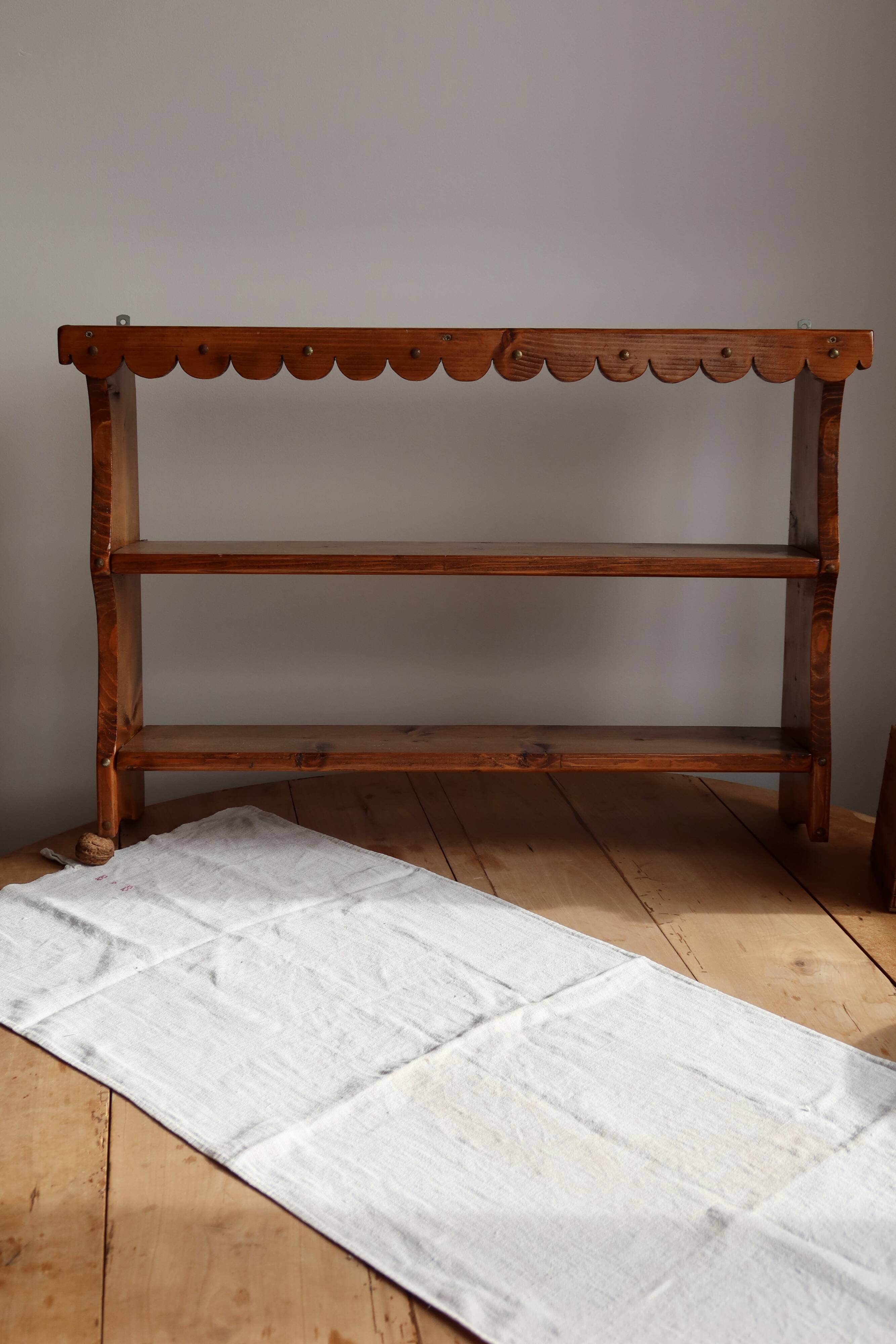 Vintage pine wall shelf with a scalloped front.