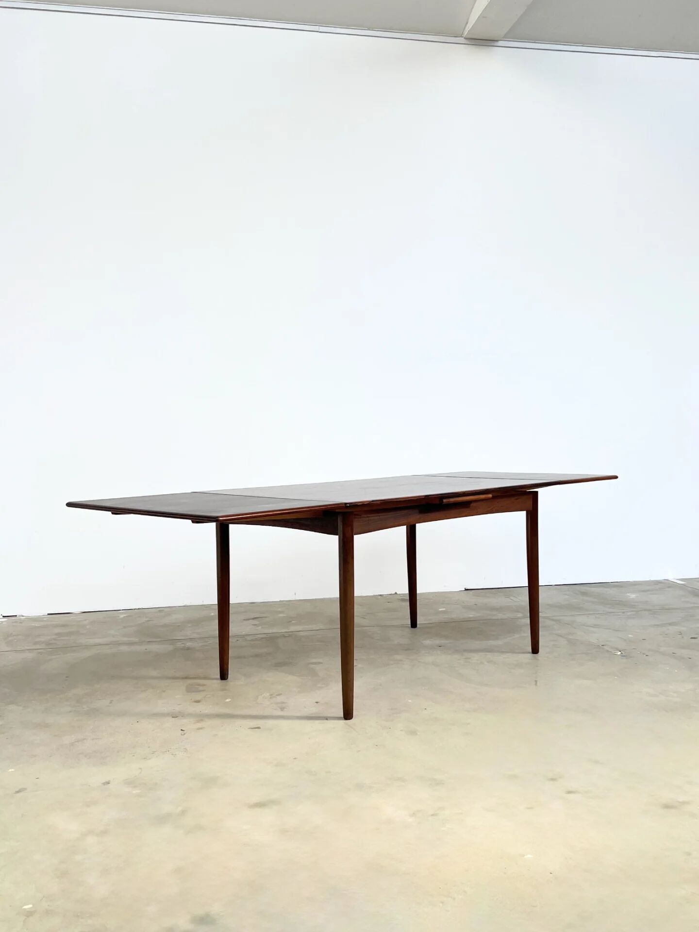 Rosewood dining table with integrated extensions — Denmark, 1960s