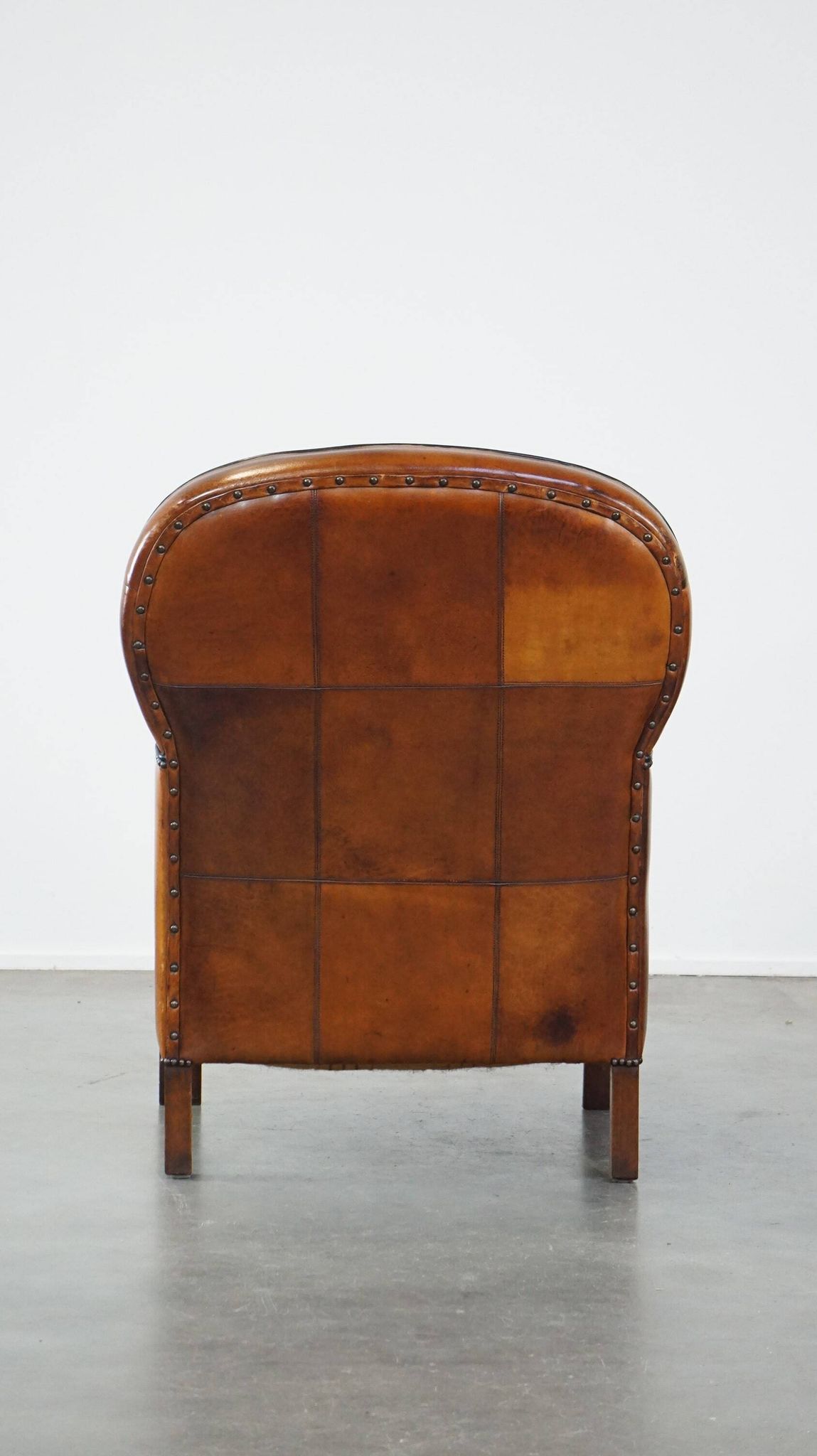 Unique, luxurious sheepskin armchair combined with wood and finished with decorative nails