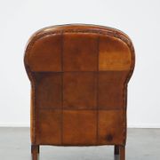 Unique, luxurious sheepskin armchair combined with wood and finished with decorative nails
