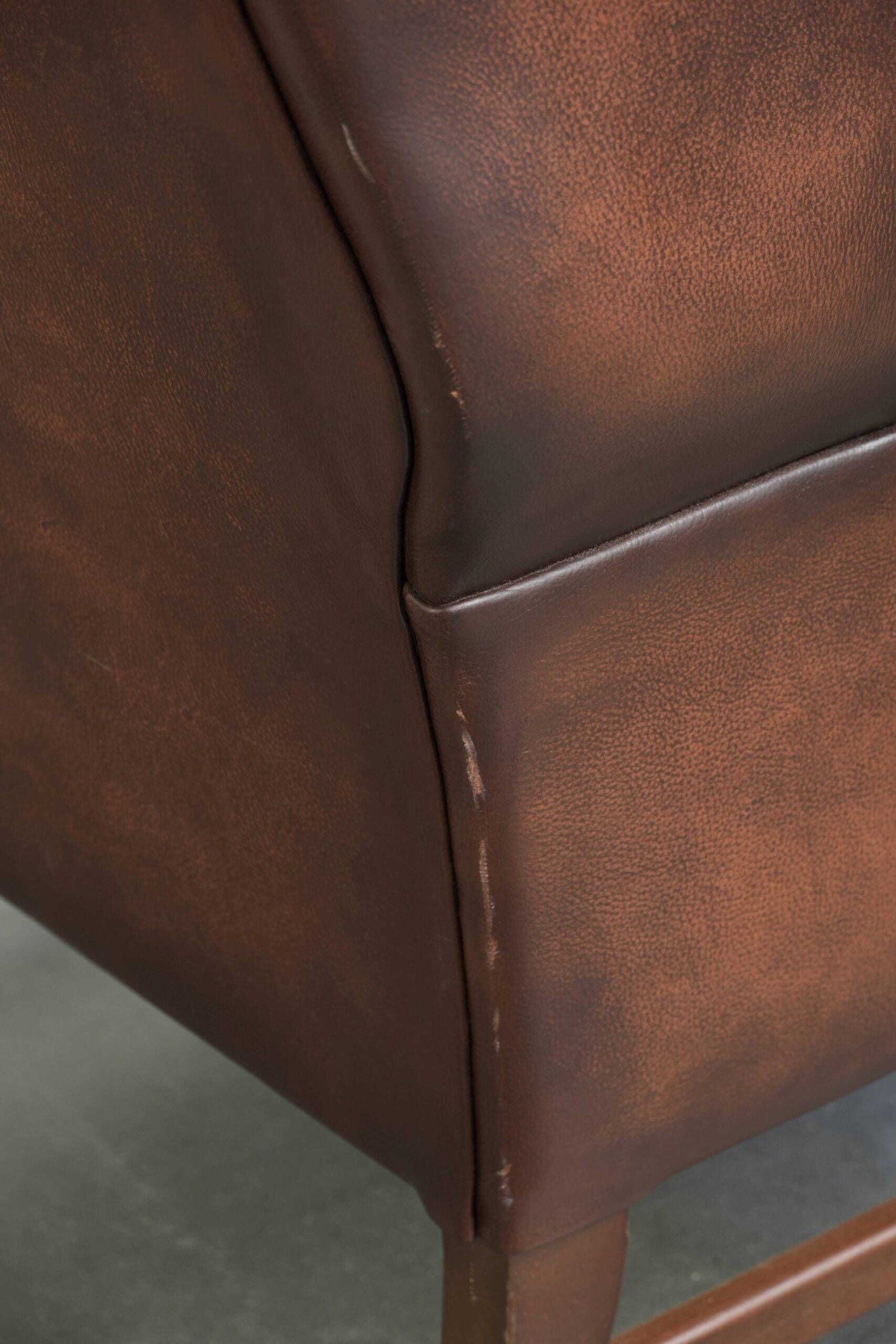 Comfortable cowhide wingback armchair in English style with a timeless look
