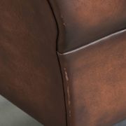 Fauteuil à oreilles en cuir de vache confortable de style anglais avec un look intemporel.