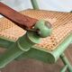 Paire de chaises safari pliantes façon faux-bambou patiné, dossiers et assises cannées et repose-bras en cuir