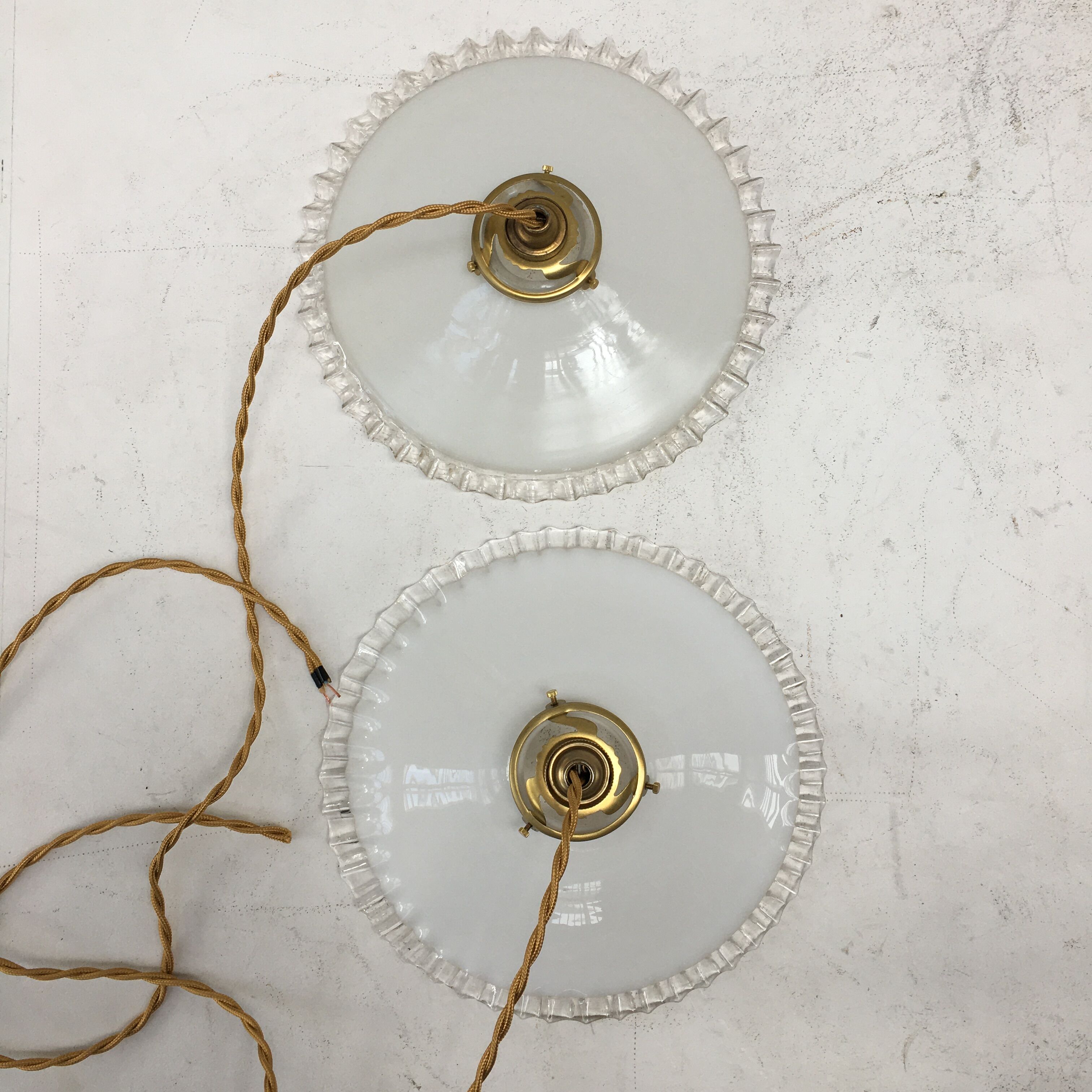 Pair of white opaline suspensions with serrated edges