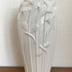 Old white art nouveau vase with flowers and dragonflies