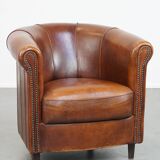 Sheep leather club chair in a cognac color and finished with piping