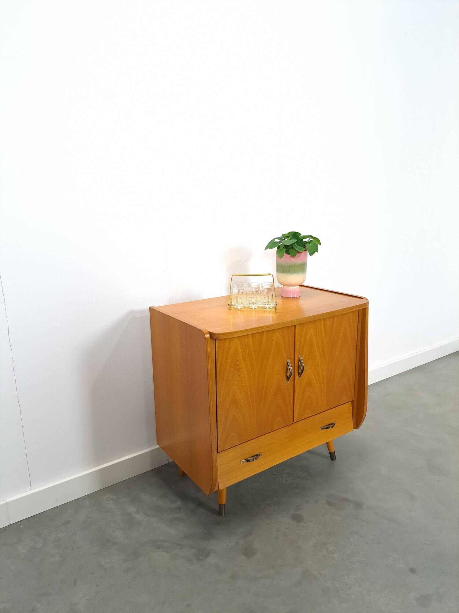 Meuble TV audio avec poignées en laiton et pieds inclinés.