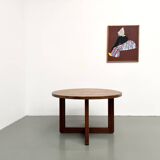 Modernist round table in solid elm, crossed legs.