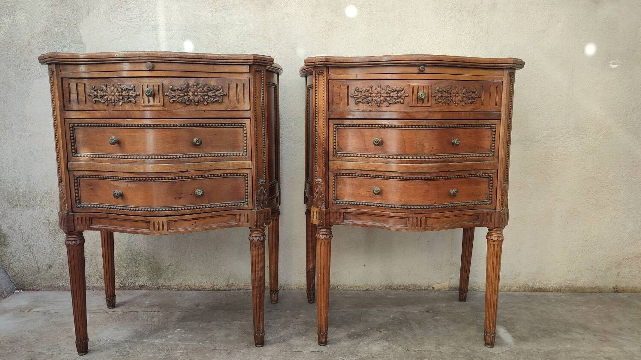 Pair of bow-fronted chests of drawers in walnut
