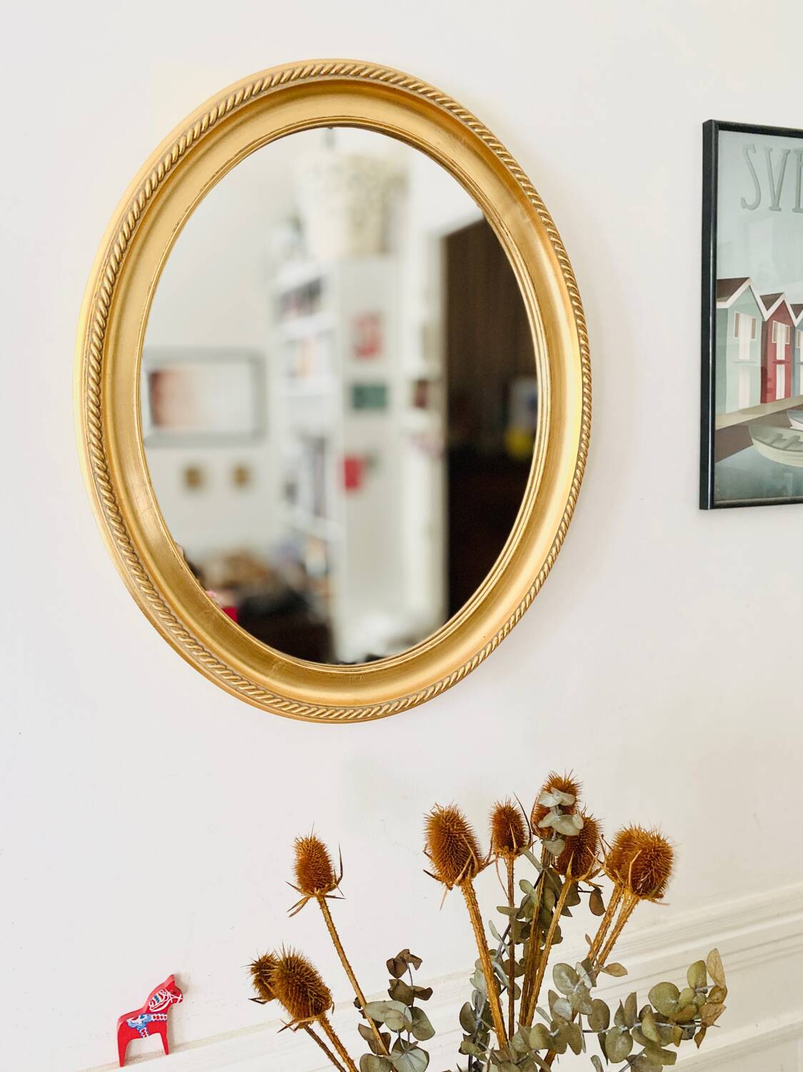 Oval wall mirror in gilded wood