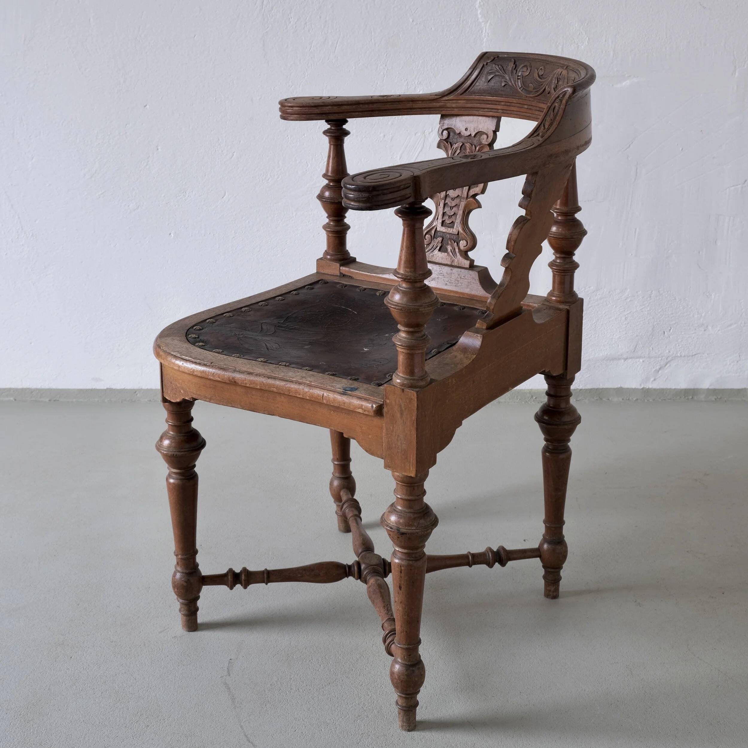 Fauteuil d'angle ancien sculpté avec assise en cuir
