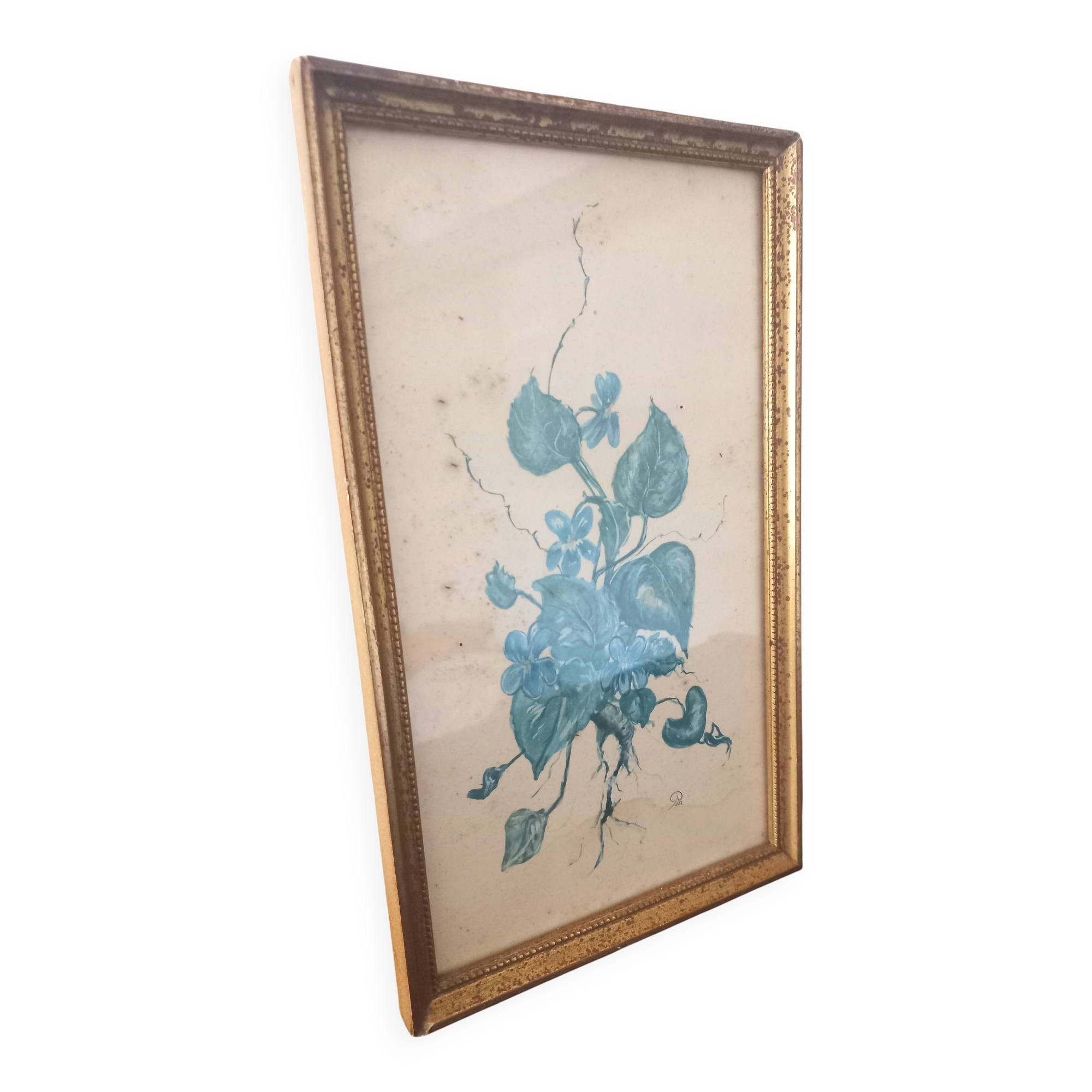 Decorative table with vintage blue flowers in a golden frame.