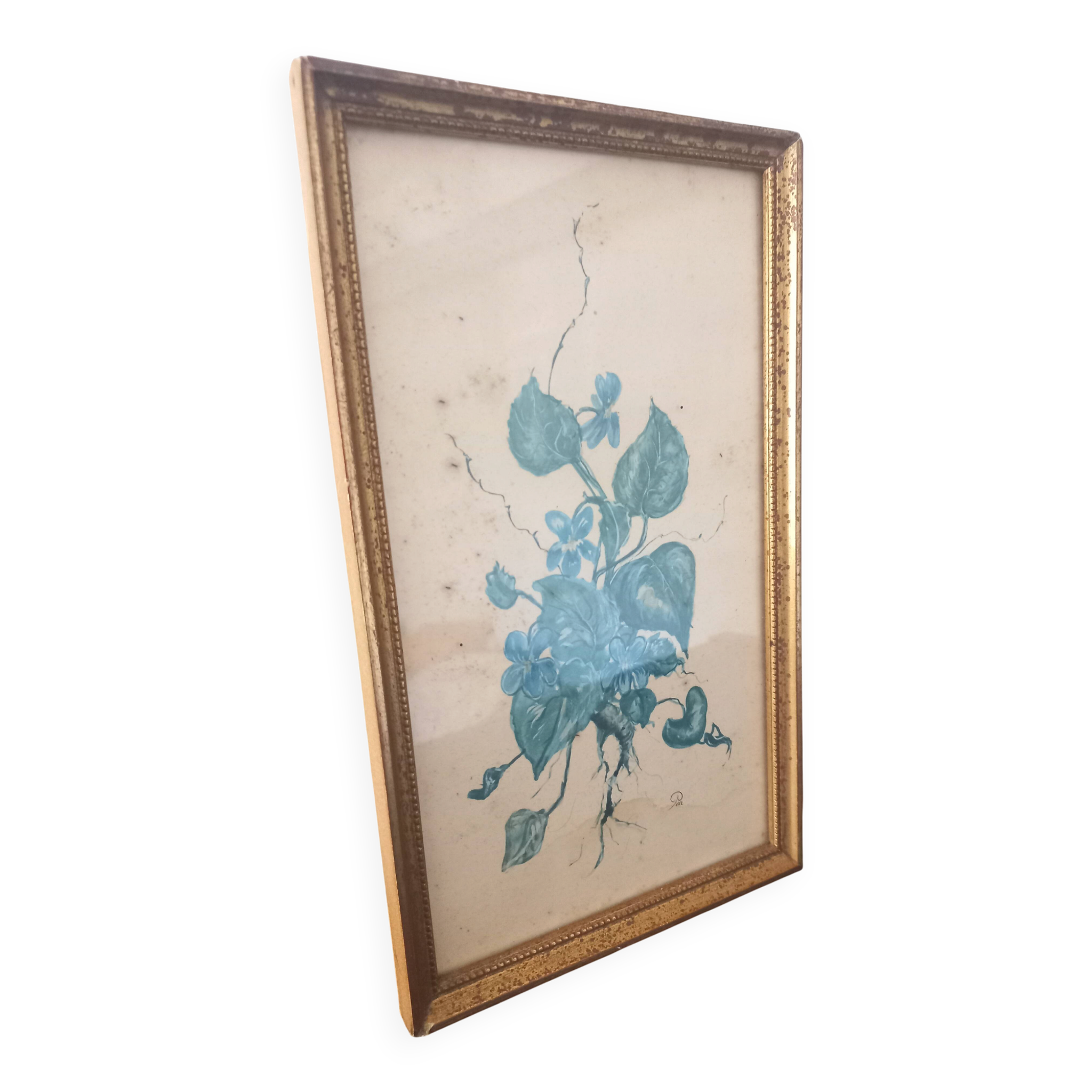 Decorative table with vintage blue flowers in a golden frame.