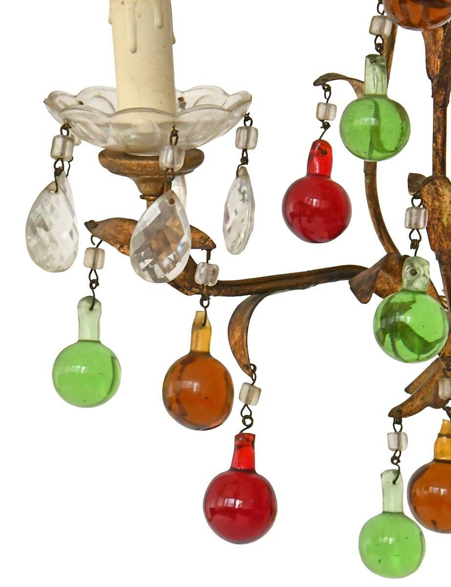 Lustrous chandelier with two wall lights decorated with foliage and pendants.